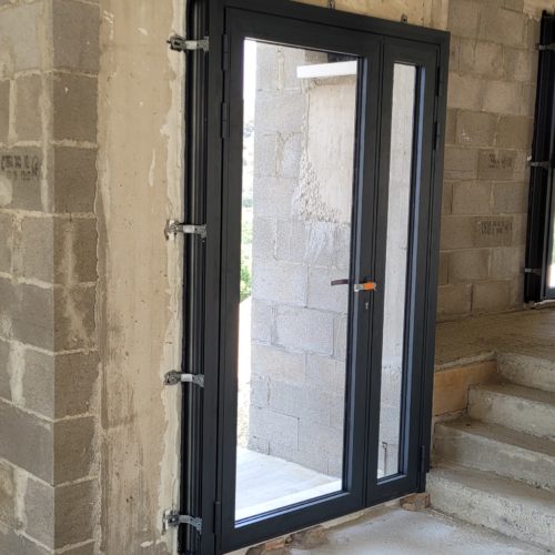 Porte-fenêtre avec partie fixe en aluminium sur construction neuve de couleur gris anthracite ral 7016