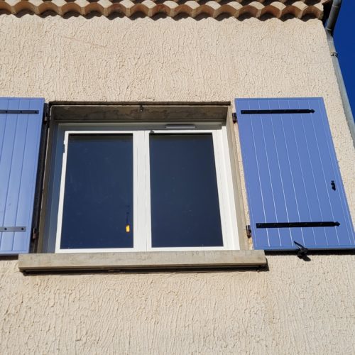 Volets battants en aluminium, de couleur bleu ral 5014 avec fenêtre deux vantaux, en aluminium, de couleur blanche (vue extérieure)