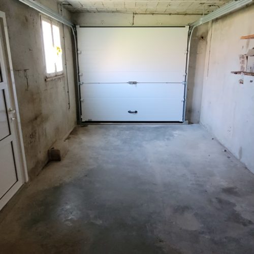 Porte sectionnelle de garage à refoulement plafond, de couleur blanche (vue intérieure)