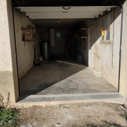 Porte sectionnelle de garage à refoulement plafond, de couleur blanche (vue extérieure)