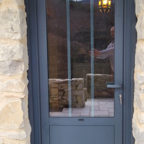 Porte d’entrée en aluminium avec soubassement, de couleur gris anthracite ral 7016, avec vitrage retardateur d’effraction isolant et petits bois intégrés