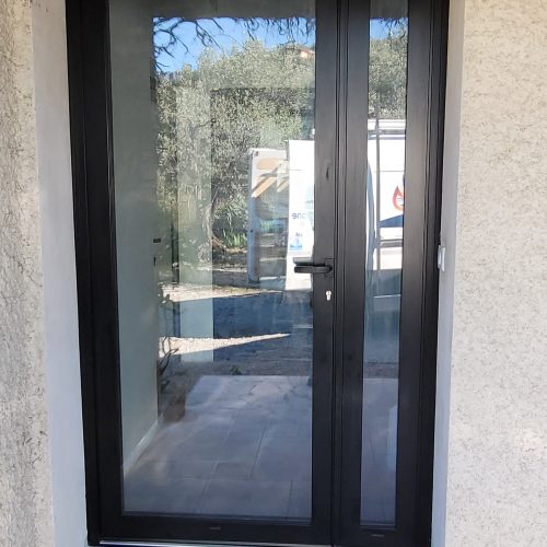 Porte d’entrée en aluminium, de couleur noir ral 9005, avec vitrage dominant