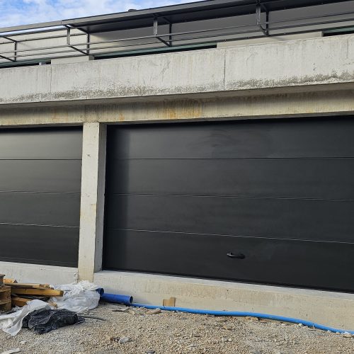 Portes sectionnelles de garage à refoulement plafond, de couleur noir, avec porte de service intégrée