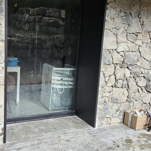 Habillage en aluminium entre la menuiserie et le parement en pierre, de largeur 60 cm et de couleur gris anthracite RAL 7016 (même couleur que la menuiserie)