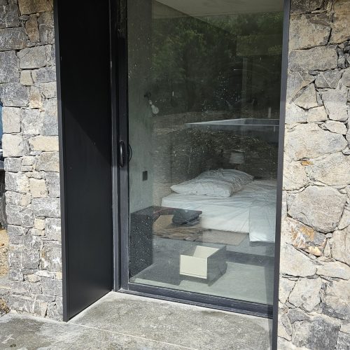 Habillage en aluminium entre la menuiserie et le parement en pierre, de largeur 60 cm et de couleur gris anthracite RAL 7016 (même couleur que la menuiserie)